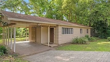 A single-story house with a covered porch, a front door, and a small window on the side.