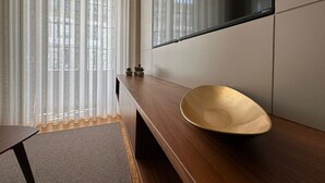 Ein modernes Badezimmer mit Waschtisch aus Holz, einem großen Spiegel und einer Duschkabine aus Glas.