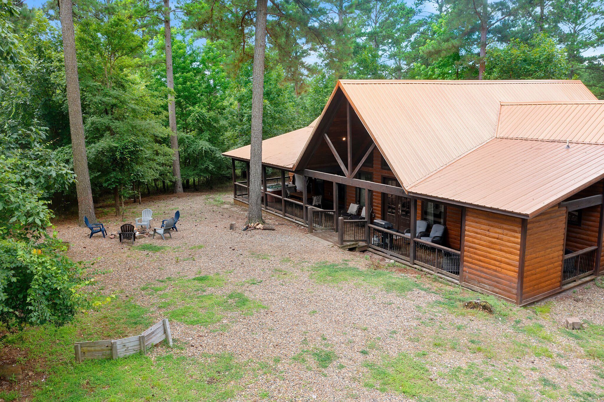Eine Holzhütte mit überdachter Veranda, einer Holzterrasse und einer Sitzgelegenheit im Freien.