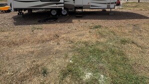 A large RV with a covered living area, a kitchen, and a sleeping area. - Cool RV with AC in Bayfield next to small lake (Bayfield)