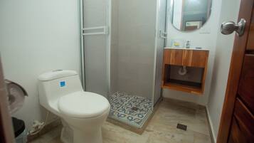Une salle de bain avec des toilettes, une douche et un lavabo.