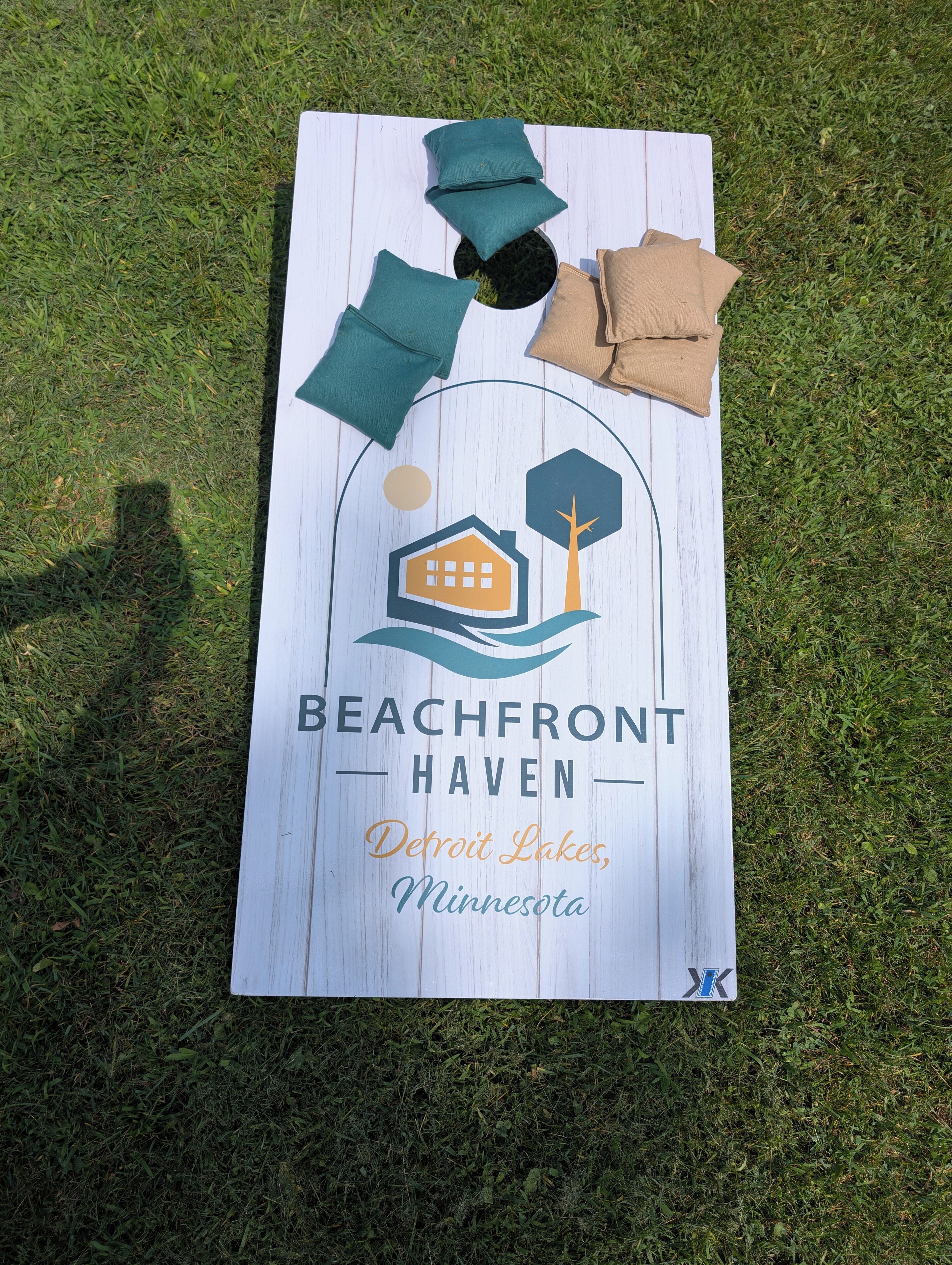 Um letreiro com tema praiano, com um ícone de casa e árvore, com a inscrição 'Beachfront Haven, Detroit Lakes, Minnesota'.