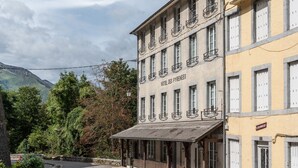 Un hotel amb façana clàssica, diversos balcons i un vestíbul cobert.