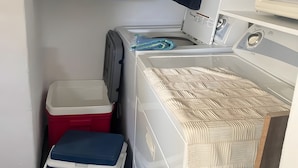 Een wasruimte met een wasmachine, een droger en een was-droogcombinatie.