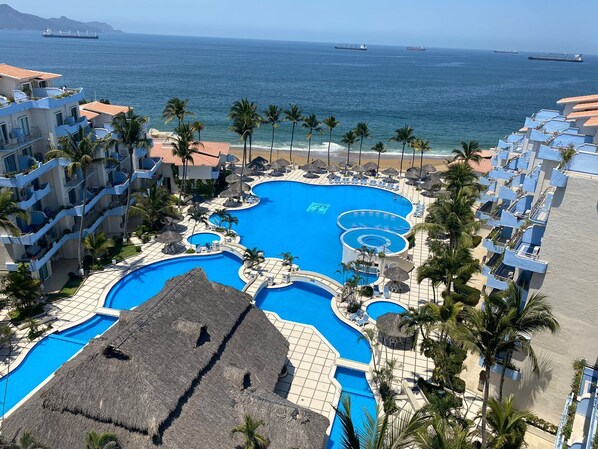 A resort with multiple swimming pools, a beach, and ocean views.