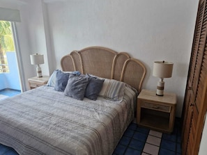A bedroom with a bed, two bedside tables, and a window.