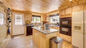 A wooden cabin kitchen with a central island, built-in oven, and a refrigerator. - Hike + Snow Play! Payson Cabin By Mogollon Rim (Payson)