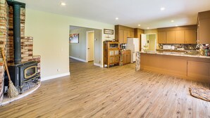 Une cuisine spacieuse dotée d’un plancher en bois, d’une cheminée en briques et d’appareils électroménagers modernes.