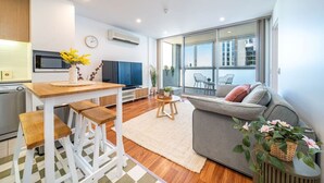A modern apartment with a kitchen, dining area, and a balcony with a view.