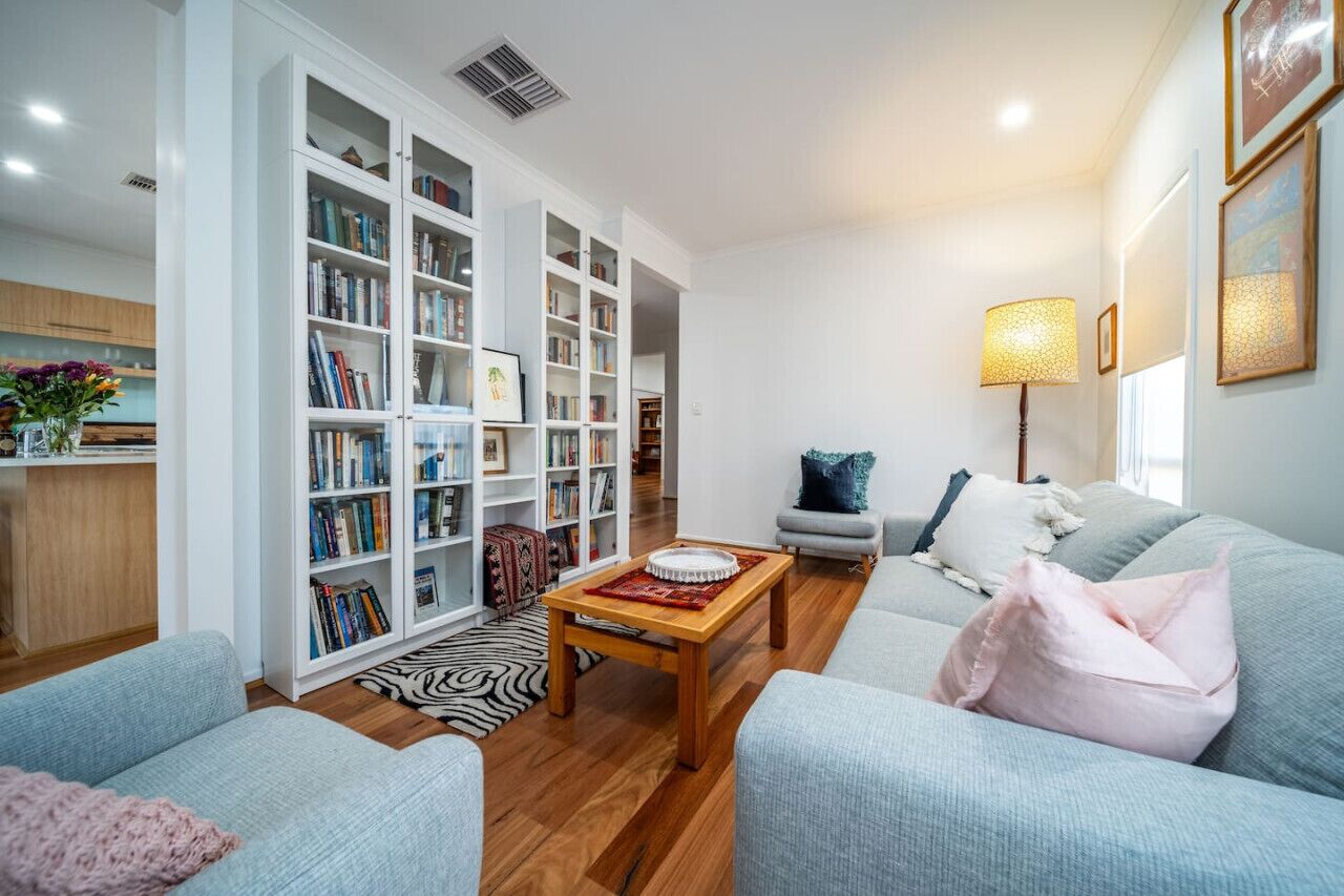A living room with a sofa, a coffee table, and a bookshelf filled with books.