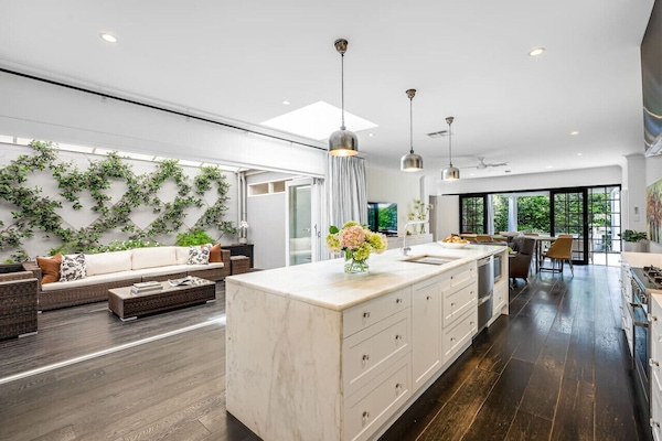 Gather around the marble island as skylights pour in natural light, flowing seamlessly into the alfresco lounge for relaxed indoor-outdoor living.