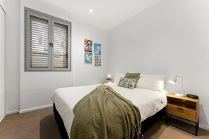 A bedroom with a bed, bedside tables, a lamp, and wall art. - Artful Escape on York - Walkable Location in the CBD (Adelaide)