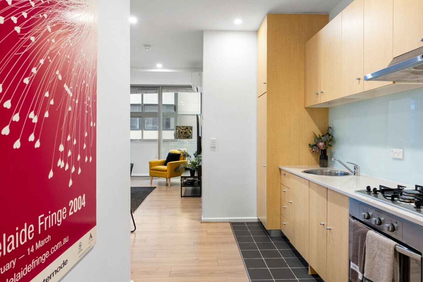 A modern kitchen with wooden cabinets, a stainless steel sink, and a gas stove.