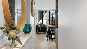 A modern kitchen with a wooden countertop, a large mirror, and a view of the cityscape through the window.
