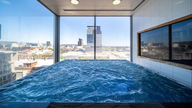 A hot tub with a city view, large windows, and a modern interior. - The Balfours Haven - City Views & Balcony (Adelaide)