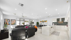 Un salon moderne comprenant un canapé, un coin repas et une cuisine.