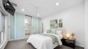 Une chambre à coucher avec un lit, une table de chevet et une commode.