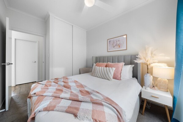 A bedroom with a bed, bedside table, and a door.
