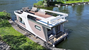 Une péniche dotée d’une terrasse, d’un coin salon et d’une petite cuisine.