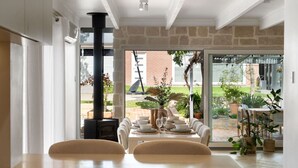Un comedor con pared de piedra, chimenea y vistas al jardín.