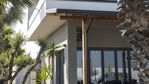 A modern multi-story building with balconies, outdoor seating, and palm trees. - Hotel Siel (Durrës)