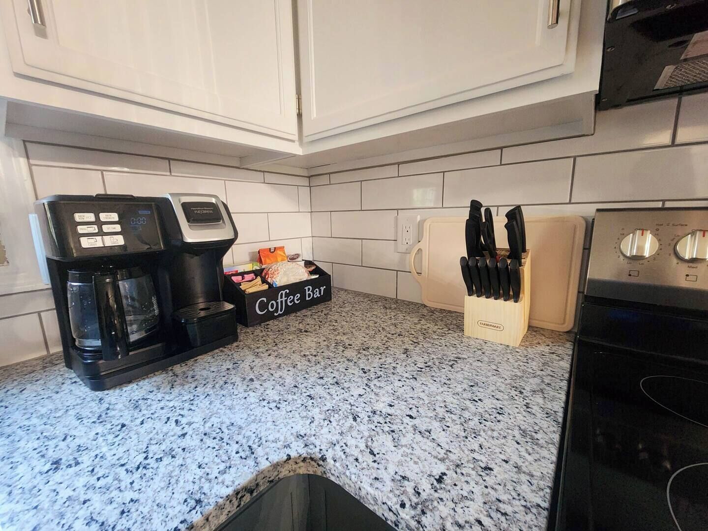 A kitchen with a coffee maker, a coffee bar, and a knife block.