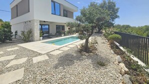 A modern two-story house with a swimming pool, outdoor seating, and a garden with trees and shrubs. - Holiday house VILLA AMORA with private pool (Linardići)