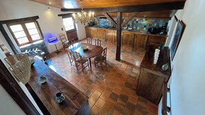 Eine geräumige Küche mit Holzschränken, einem Esstisch und einer Bar.