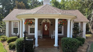 A house with a covered porch, white columns, and a central door. - Charming Cottage on 70 acre Horse Ranch, 14 miles from I-40, Carroll County, TN (Cedar Grove)