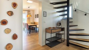 A modern interior with a staircase, wooden wall decor, and a dining area. - Overlook Lodge - Exclusive 5-Star Vacation Home on Lake Eder in Kellerwald (Vöhl)