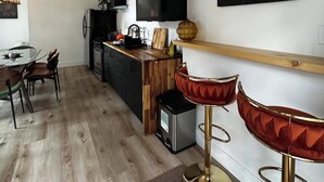 A modern kitchen with a wooden countertop, a built-in oven, and a black range hood.
