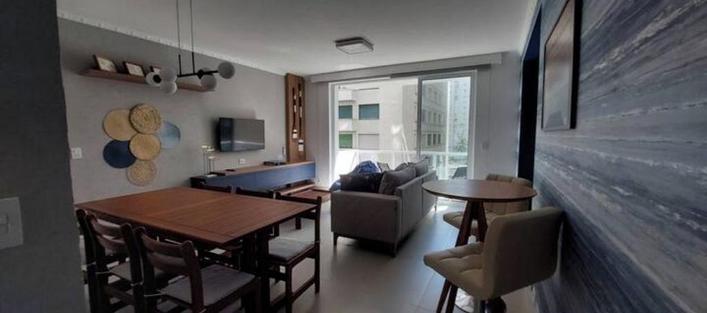 Una sala moderna con comedor, sofá y televisión.