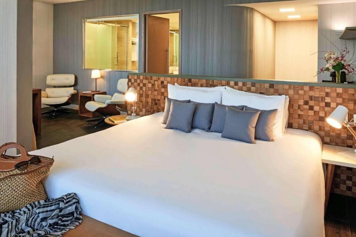 Una camera d'albergo con un letto grande, una scrivania, una sedia e uno specchio.
