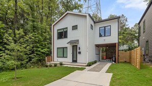 A modern two-story house with a covered garage and a well-maintained lawn.