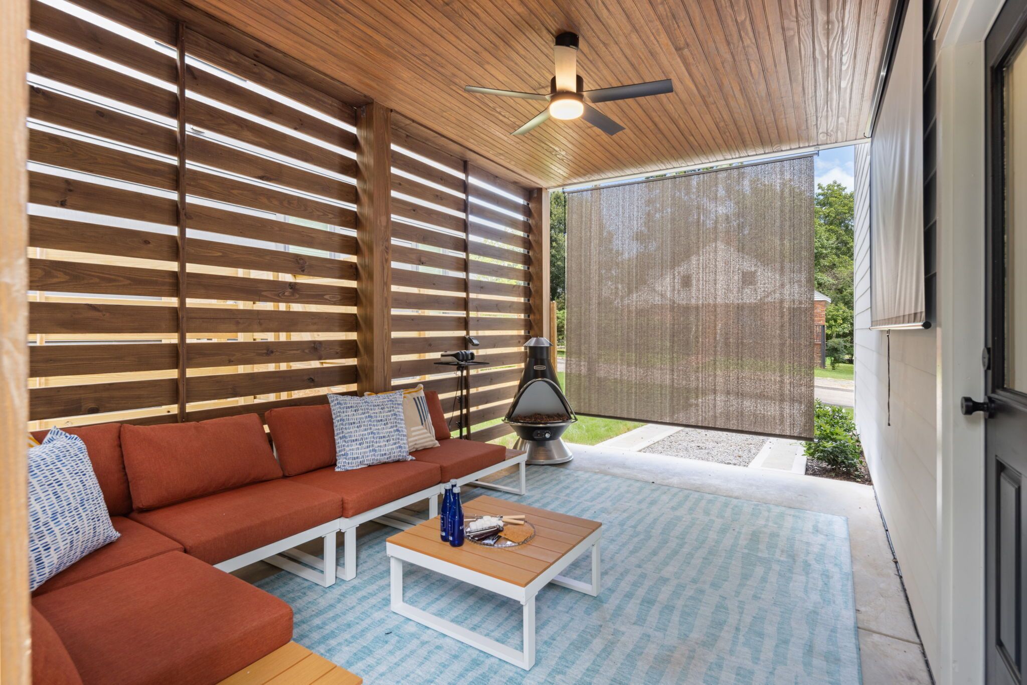 Relax on the covered patio with comfy seating, ceiling fan, and fireplace