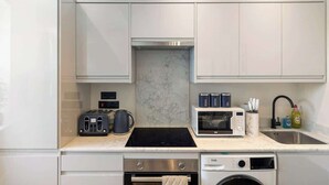 Una cocina compacta con microondas, tostadora y horno integrados.