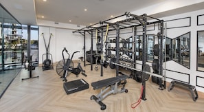 Una palestra moderna con attrezzature per esercizi, un vogatore e una panca.