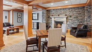 A spacious living room with a stone fireplace, wooden beams, and a cozy seating area. - ⛷️Slope side Condo- (Stratton)