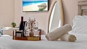 A neatly made bed with a rolled towel, a bottle of wine, two wine glasses, and a vase with flowers on a bedside table. - Channelside: Workers Paradise| Near Everything (Tampa)