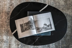 Un livre ouvert, avec deux photographies en noir et blanc, posé sur une table en marbre noir.