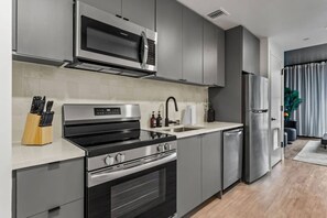 A modern kitchen with stainless steel appliances, a built-in oven, and a microwave.