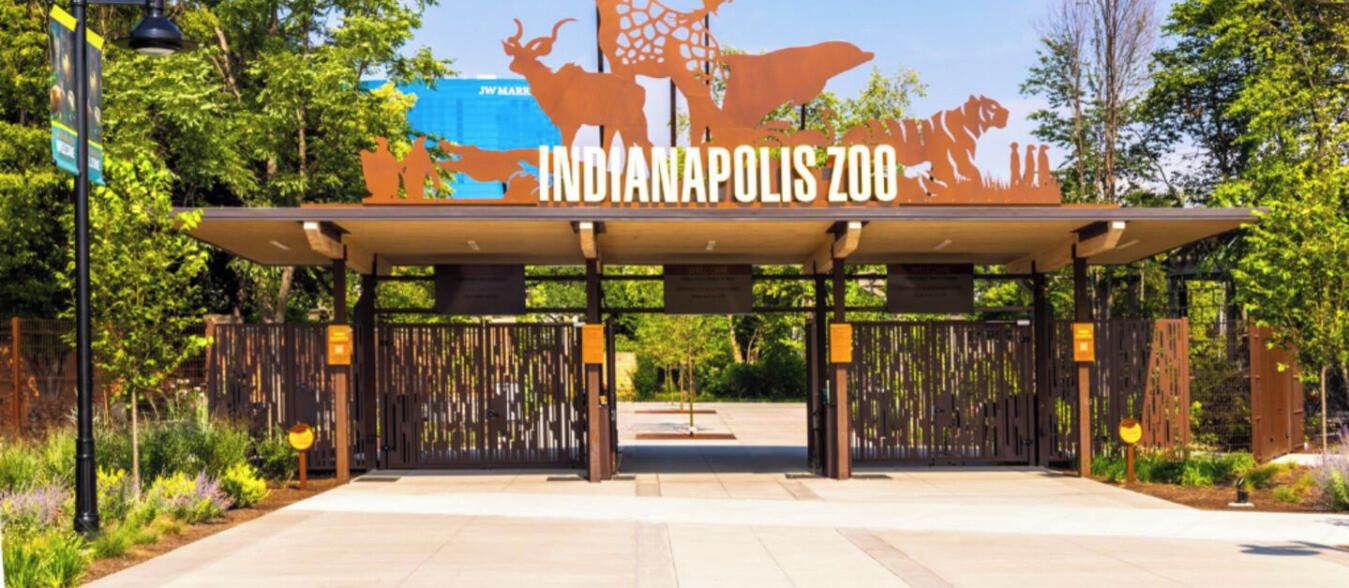 La entrada al zoológico de Indianápolis, con un gran letrero y una pasarela techada.