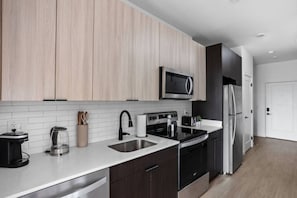 A modern kitchen with a microwave, stove, sink, and refrigerator. - in United States of America, Indianapolis (Indianapolis)