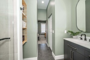 A modern bathroom with a shower, vanity, and a mirror. - The Baymiller Row - For 6! (Cincinnati)