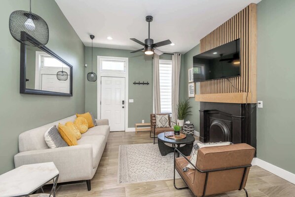 A living room with a sofa, coffee table, and a fireplace. - The Baymiller Row - For 6! (Cincinnati)