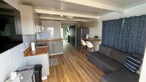 A compact living space with a kitchenette, a sofa, and a dining area.