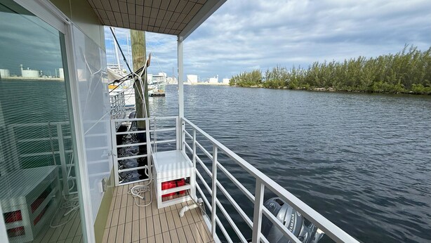A boat deck with a Yamaha outboard motor, a white railing, and a view of the water and distant shoreline.
