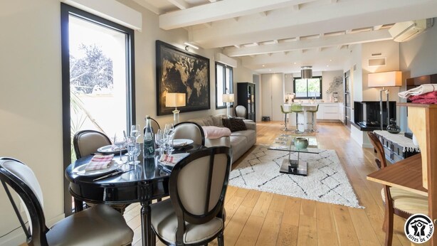 Een moderne woonkamer met een eethoek, keuken en een groot raam met uitzicht.