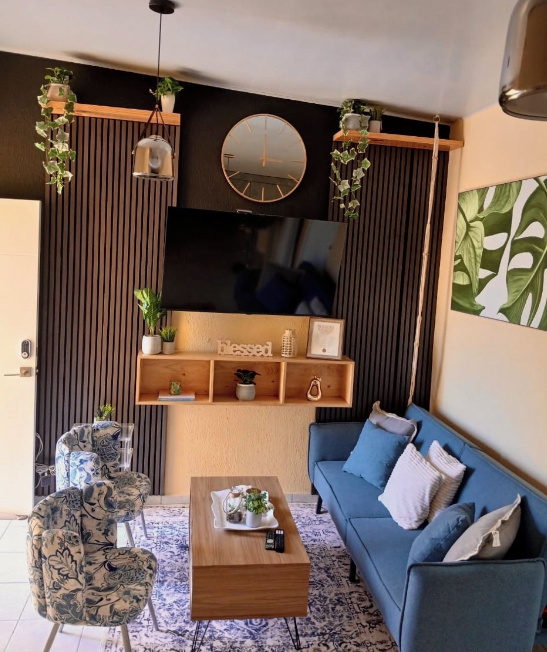 A modern living room with a sofa, coffee table, and decorative plants.
