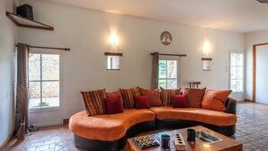 Una sala moderna con un sofá seccional curvo, una mesa de centro de madera y una chimenea.